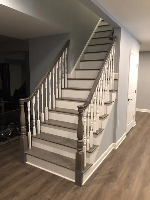 Custom curved staircase with dark hardwood treads and painted risers